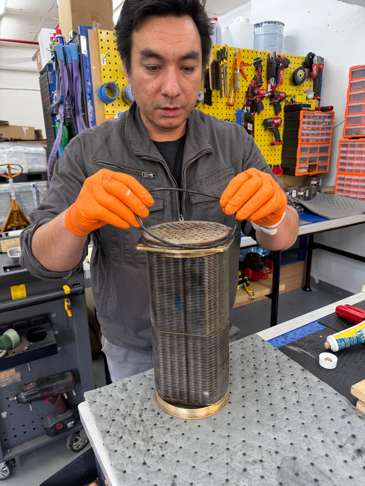 Technician servicing a marine heat exchanger core in the Hong Kong workshop